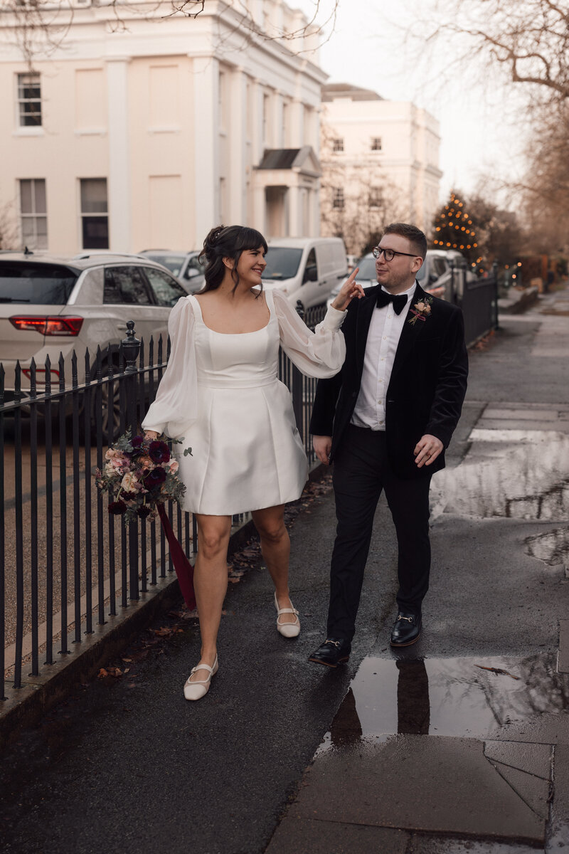 Jessica and Francis walk hand in hand through the streets of central London on their way to the wedding reception in Soho