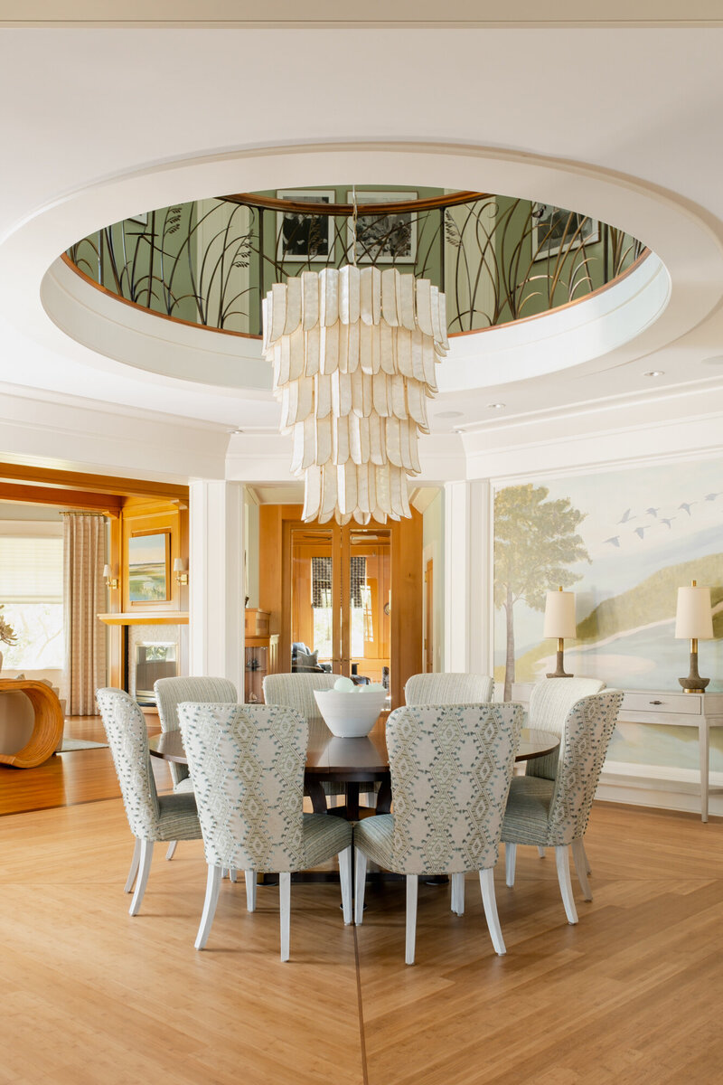 Interior remodel of a stately coastal home on the Intracoastal Waterway in Wilmington, NC, showcasing serene, watery color tones throughout. The updated design features misty dining room hues, cool blues in the primary bathroom, and a reimagined kitchen. New flooring and a complete overhaul of the primary bath enhance the home's panoramic water views, creating a classic coastal dream home.