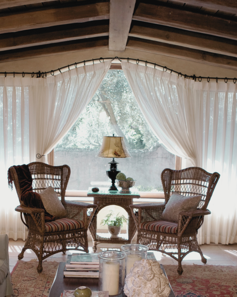 Rustic Spanish style  living room with beamed ceiling and matching wicker armchairs and table