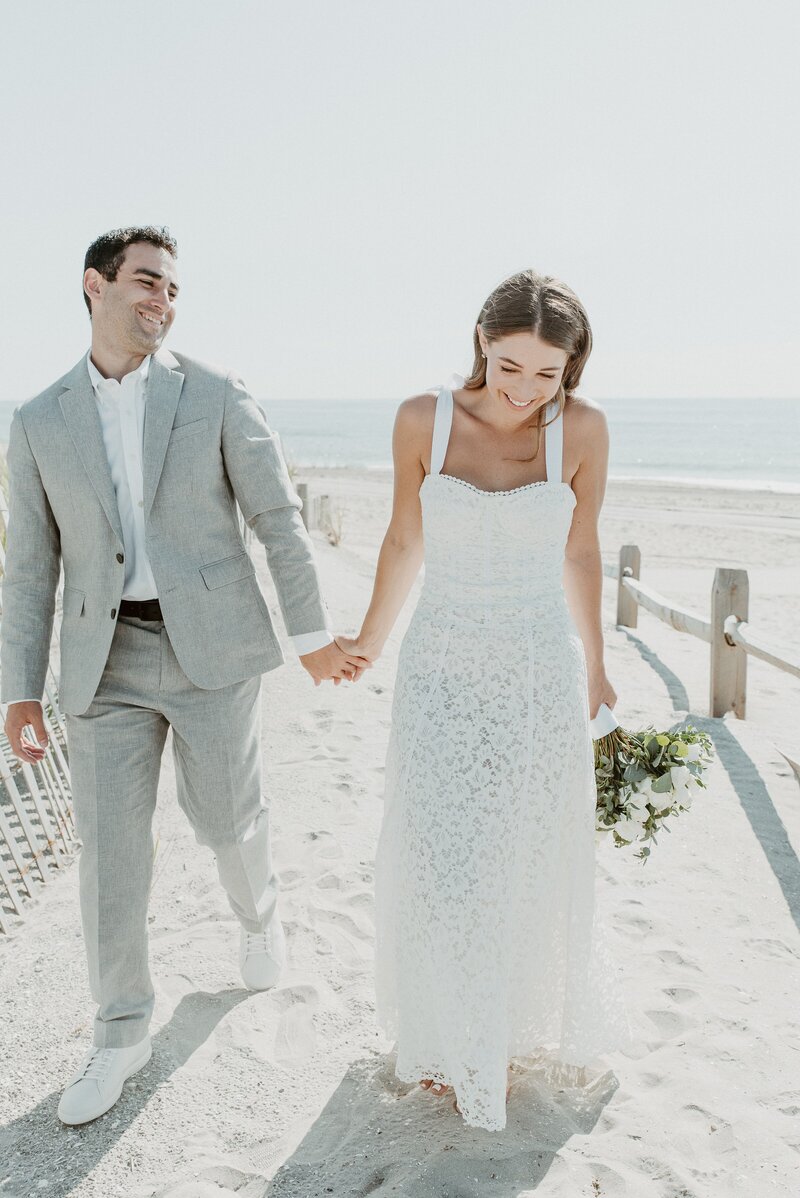 bride and groom walking on beach in La Jolla
