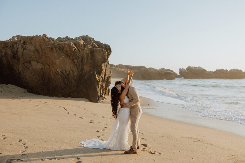 bride and groom embracing on beach