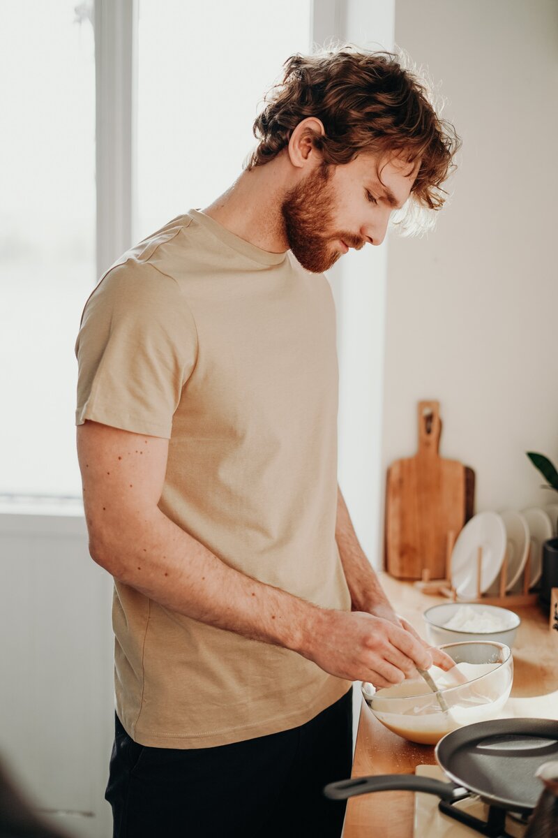 man-in-brown-shirt-holding-bowl-on-wooden-table-3692763