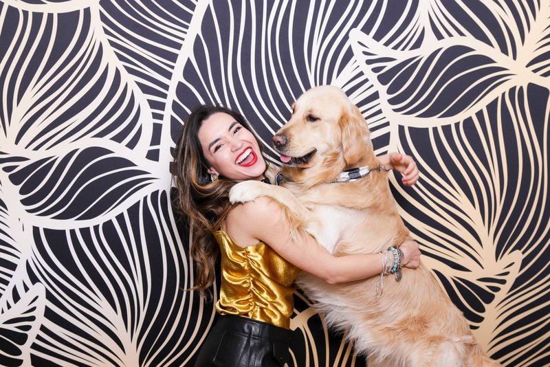girl and dog playing front of a damask backdrop for a photo booth photo
