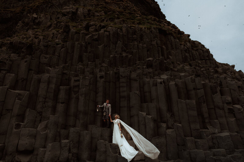 groom spins bride infront of Icelandic waterfall