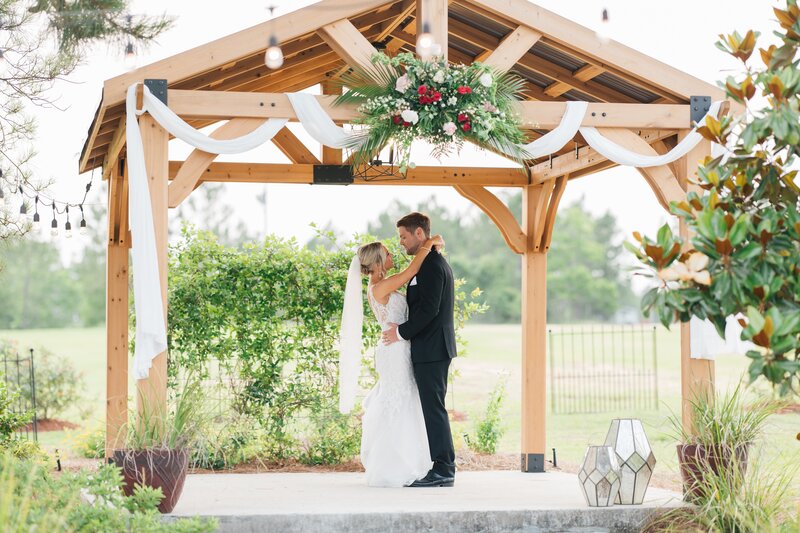 bride and groom slow dancing under a gazebo