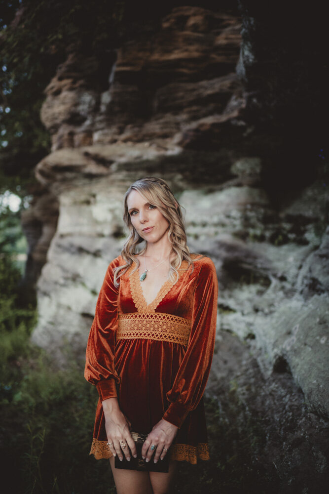 Caroline Weiss holding her journal in nature, reflecting her process of energy alignment and personal transformation.