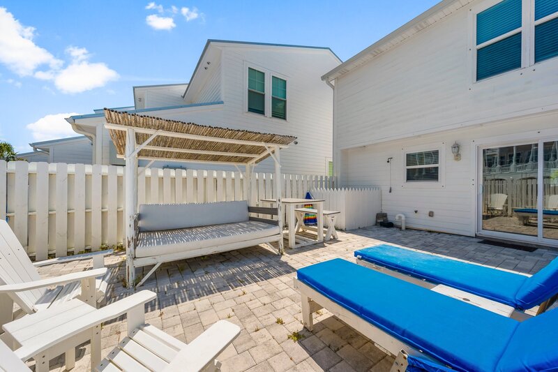 Cozy outdoor dining space with shade structure and loungers at Tropical House, ideal for PCB vacation rentals with style and space.