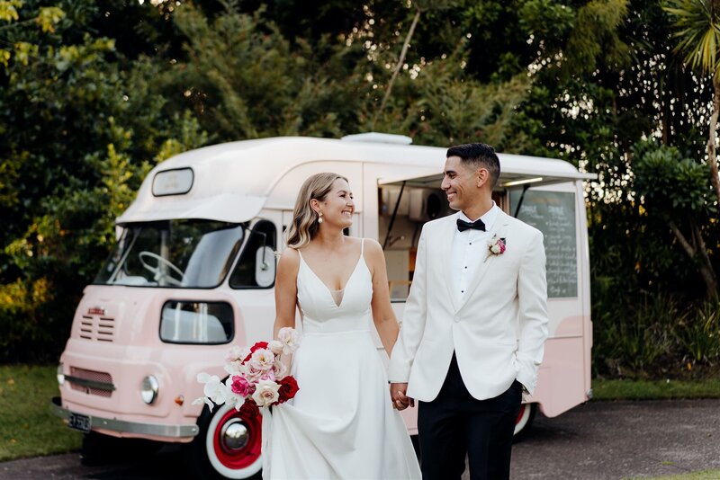 A bride and groom walking in front of the Duck Island Ice cream truck at Narrows Landing a popular Waikato Wedding Venue
