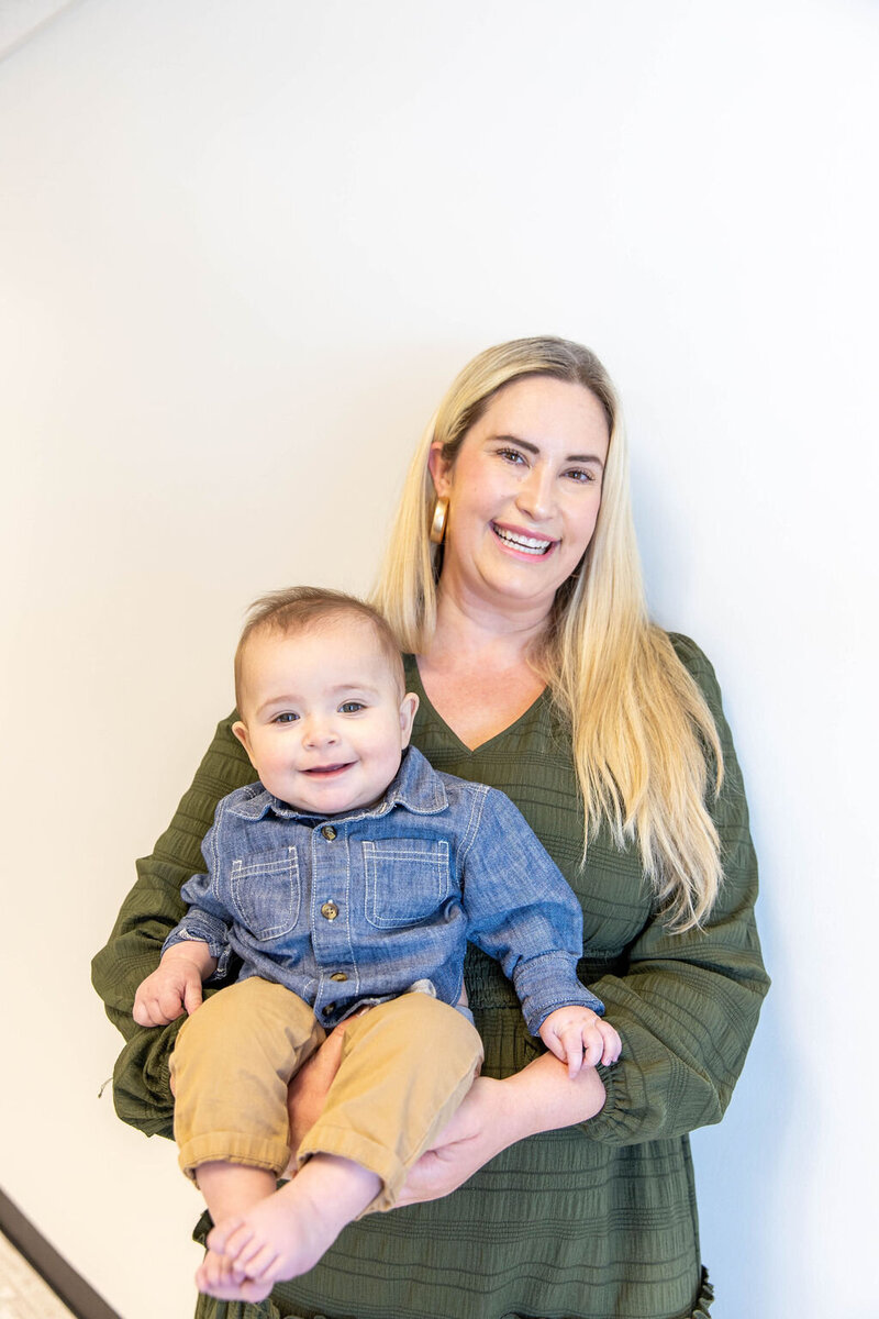 Women smiling as she holds her smiling baby