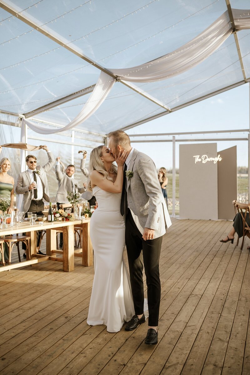 Bride and groom kissing at their reception at Alberta wedding venue, Gardenview Estates 