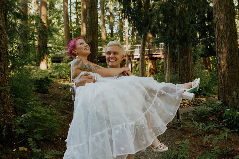 couple in wedding attire embracing in front of lowers