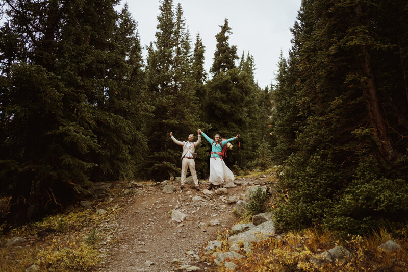 bride and groom hiking through trees