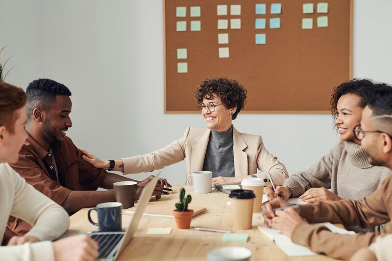 group of people sitting at table talking in conference room