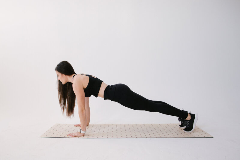 Founder of Good For The Swole, Becky Burgess, planks on tan yoga mat