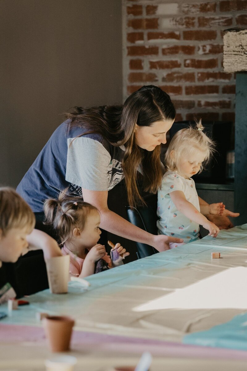 A woman helping children with an activity