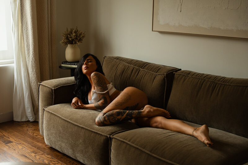 female lounging on a couch with hands in hair