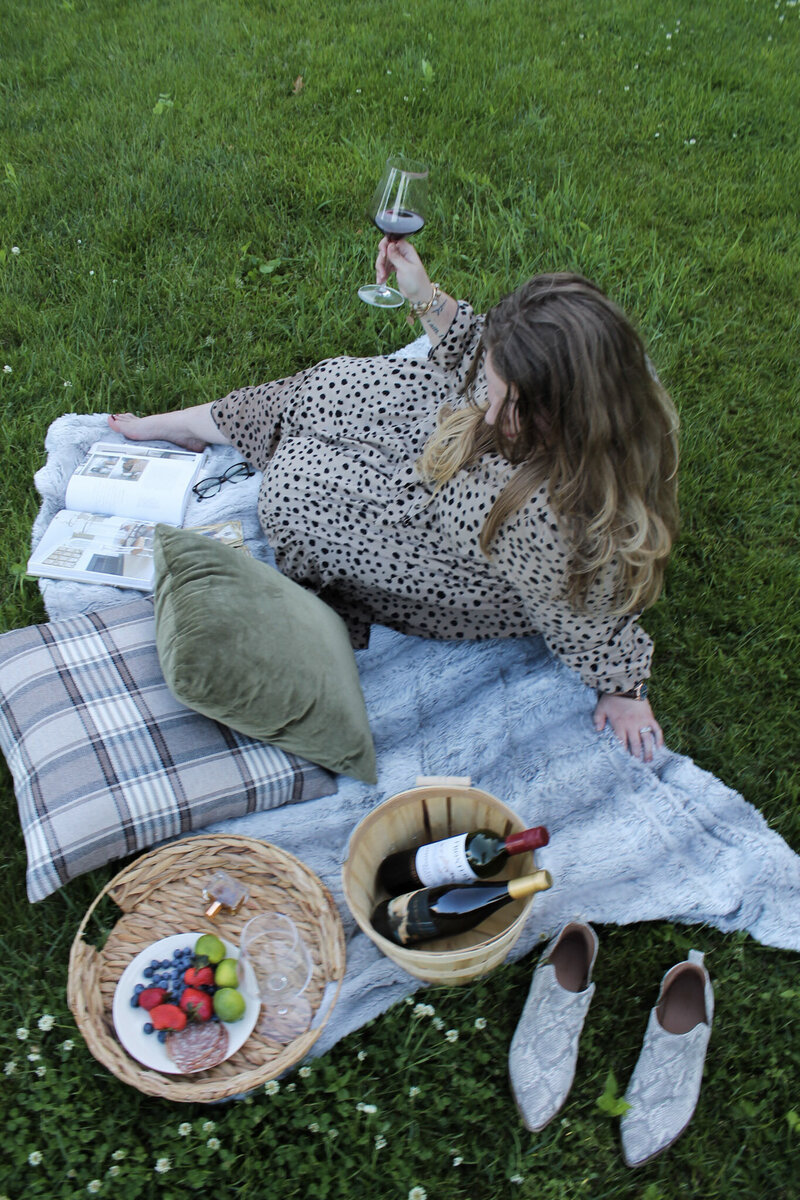 Striking editorial image of life coach Ashleigh Henry, inviting high-performing women into slower rhythms, self-reclamation, and deep internal safety while enjoying red wine and charcuterie.
