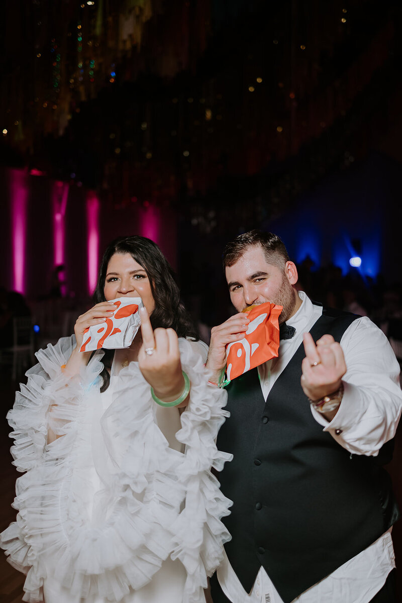 bride and groom showing off wedding rings