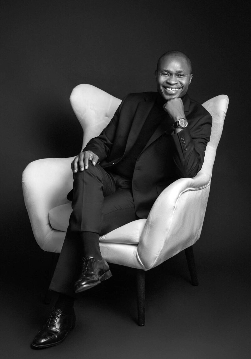 Confident man in black suit posing confidently in a studio portrait