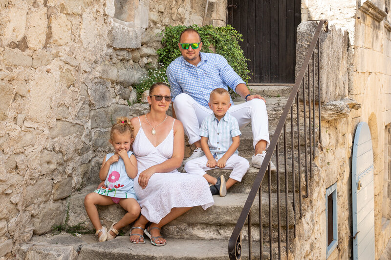 family is sitting on old steps