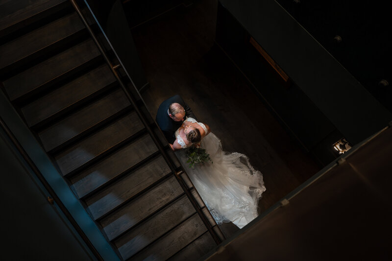 View looking down on a newlywed couple in a staircase 