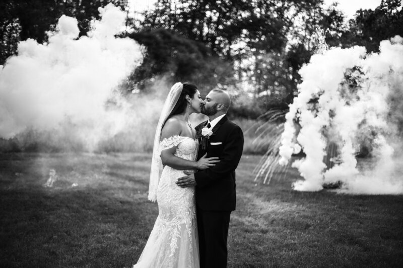Couple kisses in the middle of smoke bombs at Port Farms wedding