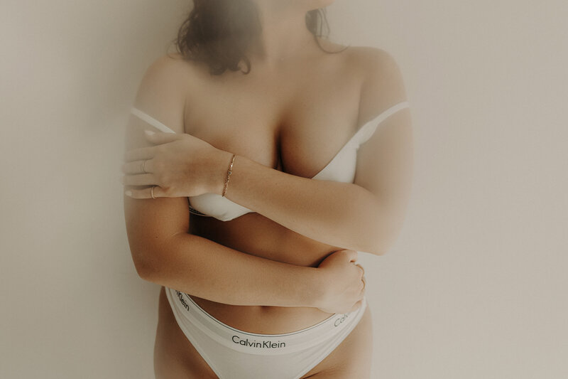 A woman holding her body wearing a simple Calvin Klein set.