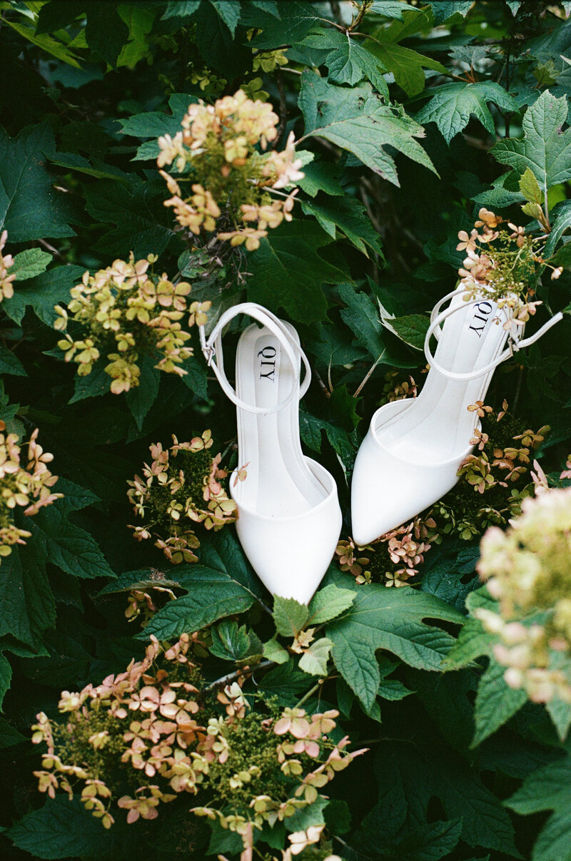 Close-up of handcrafted wedding shoes on bush at a Lake Como villa.