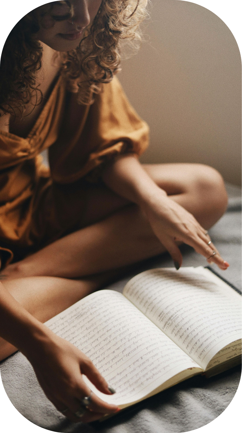Woman in a soft brown dress writing in a notebook, representing online anxiety therapy and coaching for millennial women experiencing burnout, people-pleasing, and emotional overwhelm.