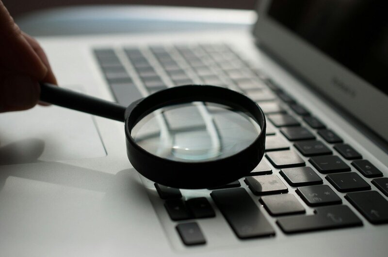 Une loupe est posée sur un clavier d'ordinateur, au programme : audit SEO à Angers !