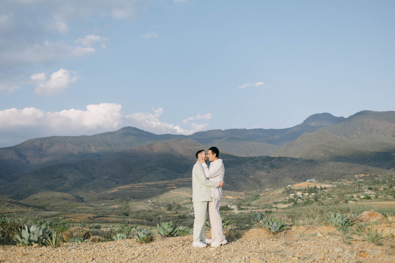 LGBT Wedding: Romantic Couple Embracing and Gazing Lovingly at Each Other Against Mountainous Backdrop