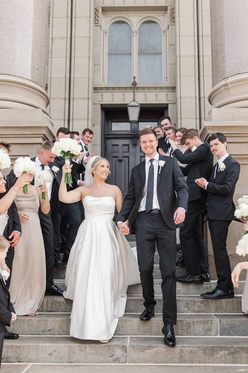 bride and groom celebrating outside of a church on their wedding day