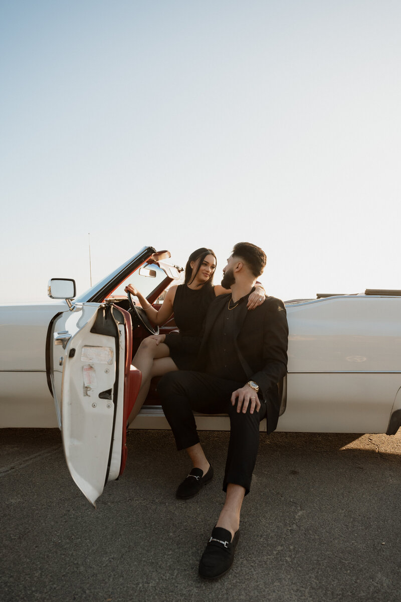 chic elopement photo with bride and groom sitting in front of painting