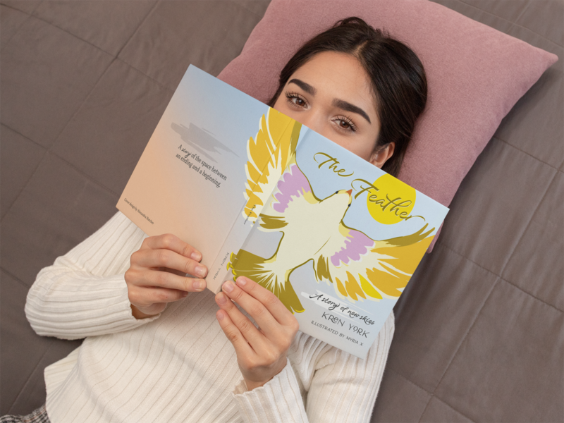 mockup-of-a-woman-lying-down-holding-a-book-31039