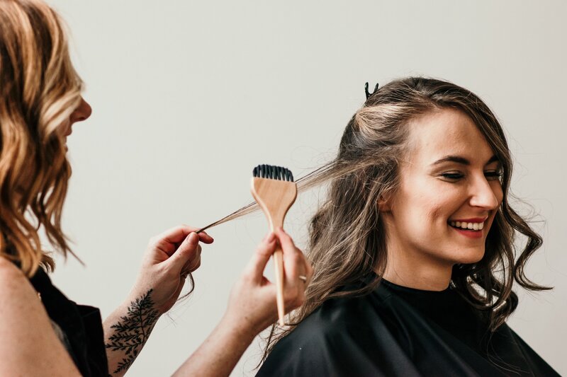 brunette woman in salon chair smiling