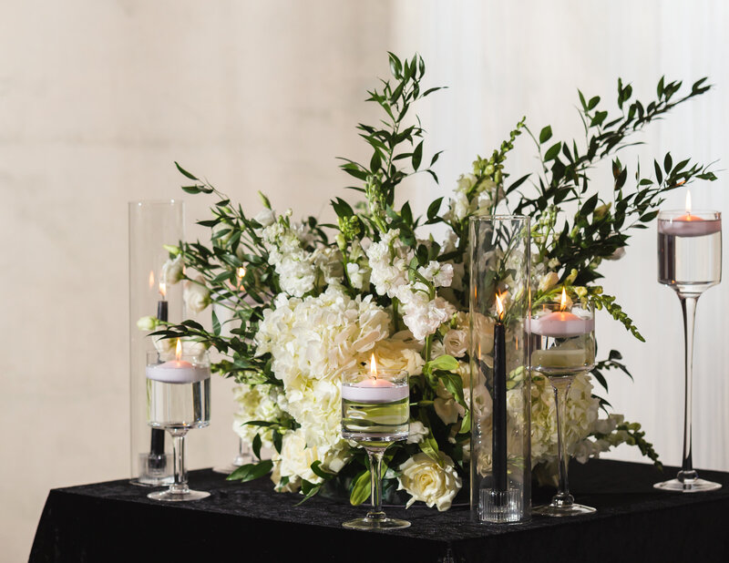 white flowers and tea candles sitting on a table