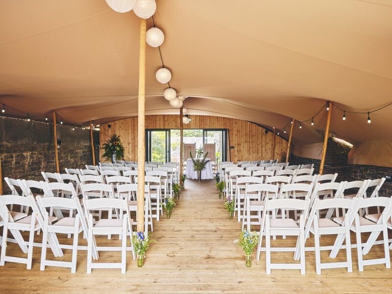 The fort terrace set up with a stretch marquee and chairs set up for a wedding ceremony