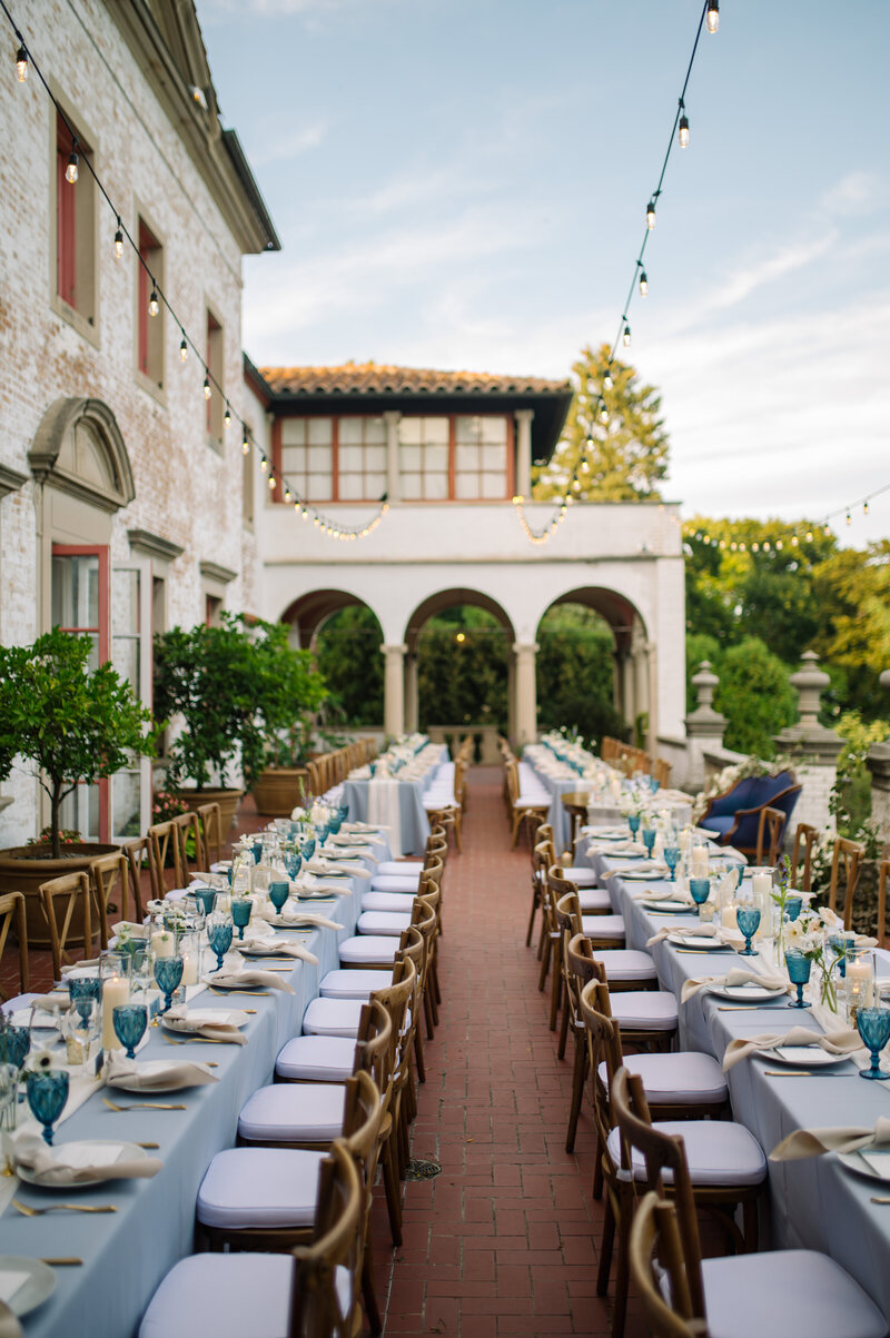 al fresco long family style wedding dinner tables setup on the terrace at villa terrace in milwaukee wisconsin