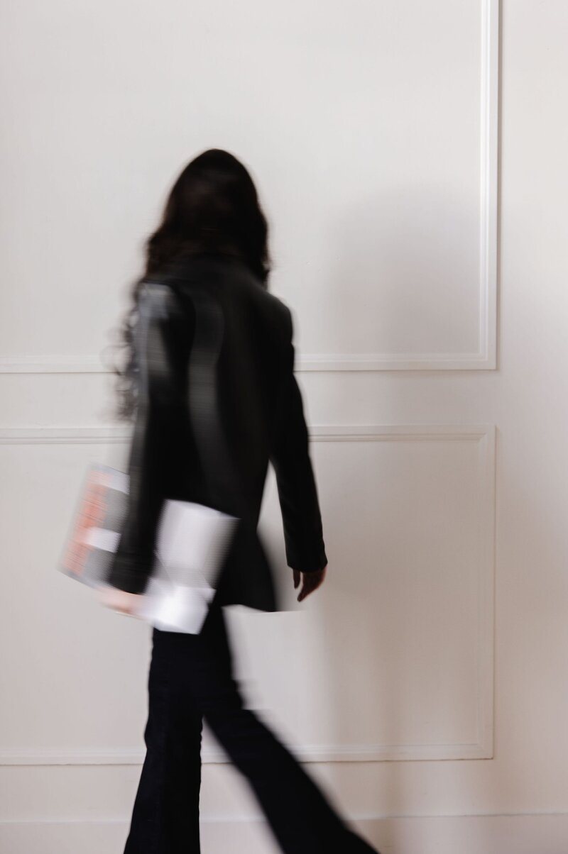 Blurry brand photo of woman walking in leather jacket