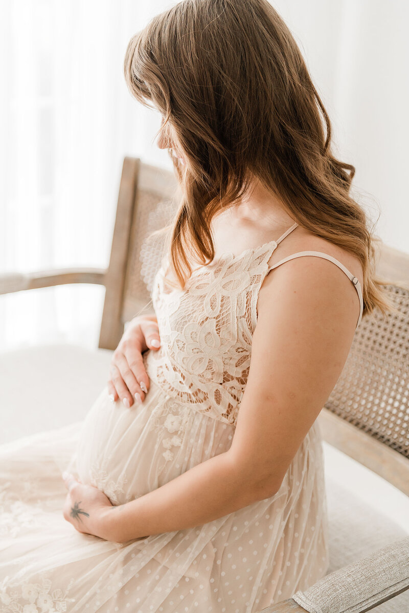 pretty regnant woman smiling down her pregnant belly