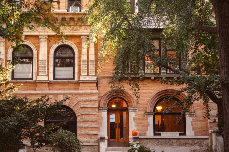 Ornate historic brownstone building in NYC with arched windows.
