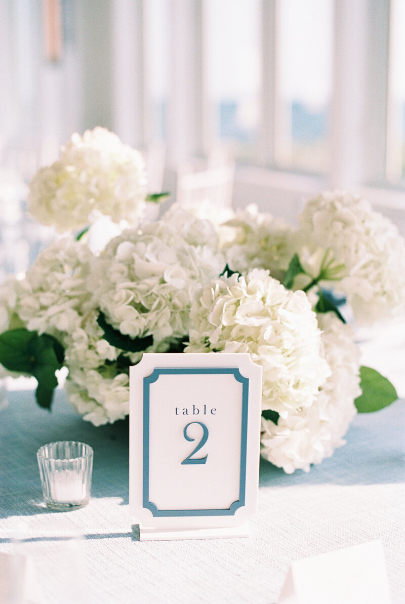 white hydrangea centerpiece with a blue and white table number at Wychmere Beach Club