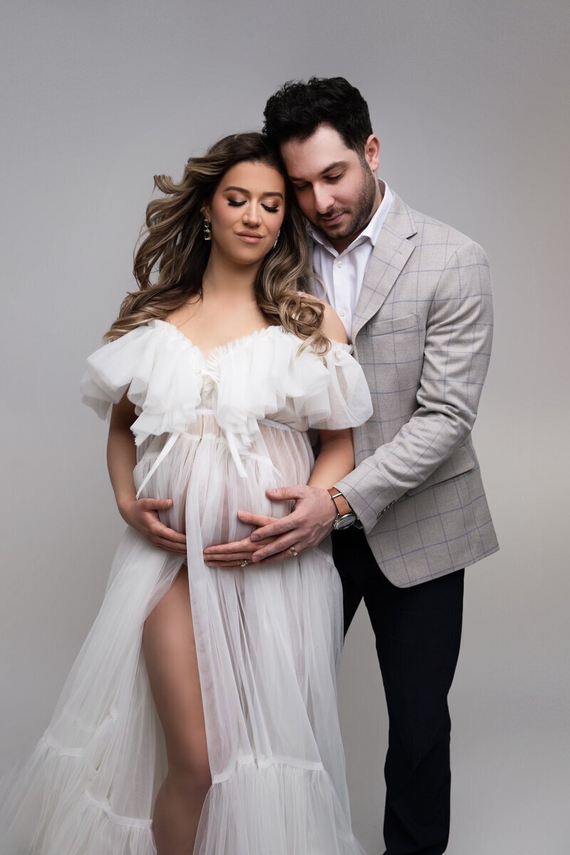 Expecting parents holding baby bump, taken by new jersey maternity photographer