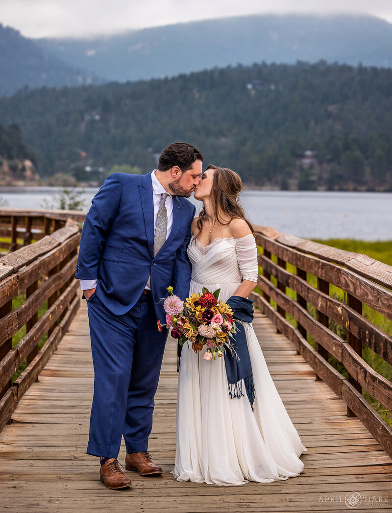 Kissing on the Wood Boardwalk on a wedding day at Evergreen Lake House