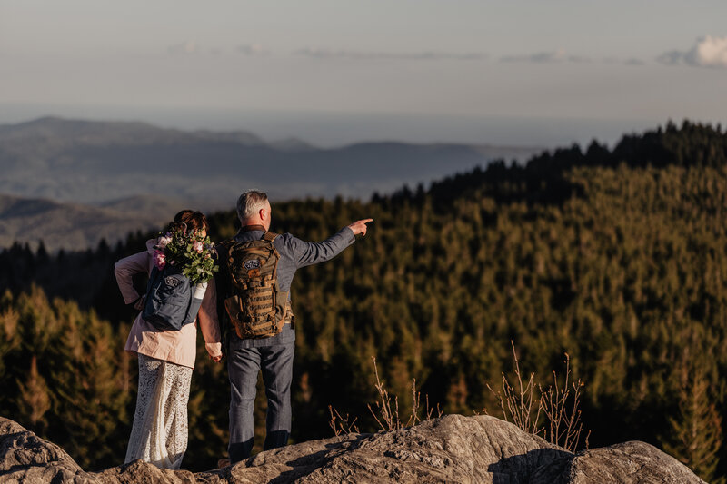 Bride and groom hiking up a mountain for elopement