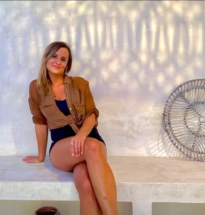 Sylvana Kozak smiling and engaging with clients in a bright, modern Tulum workspace, guiding high-level entrepreneurs through strategic transformation.