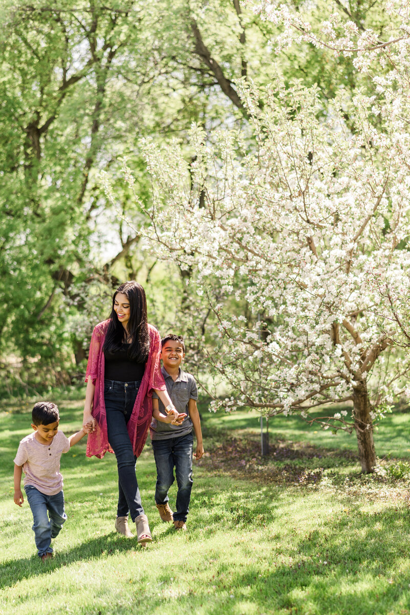 two sons walk with their mother holding hands by Yantes Photo