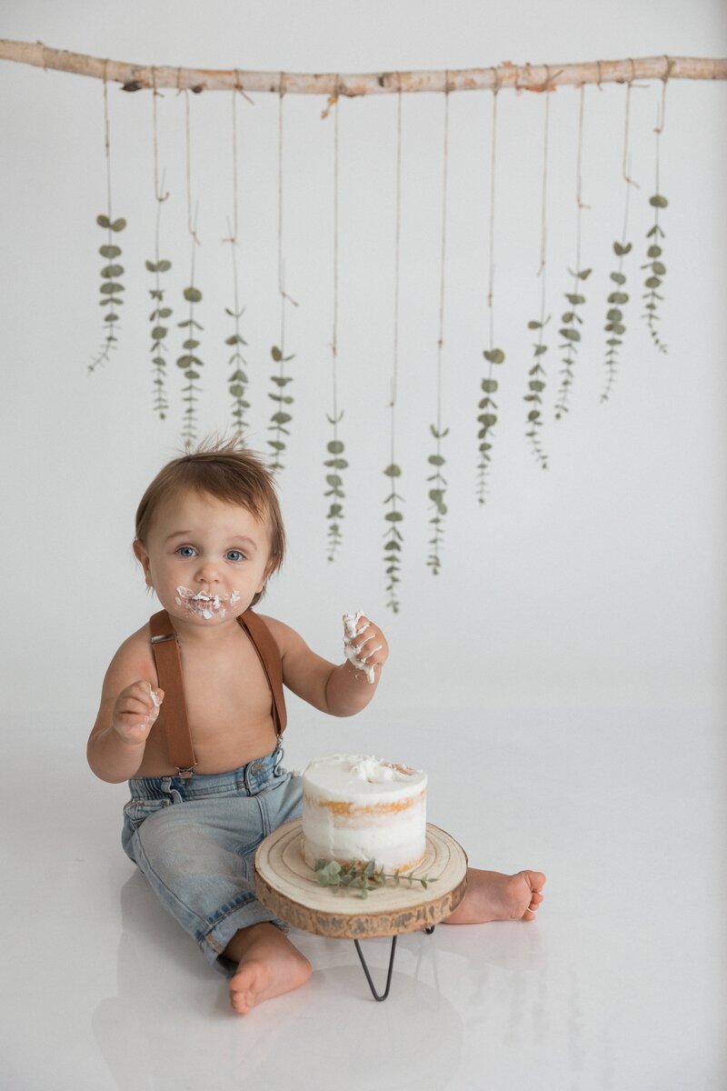 one year cake smash with child eating cake