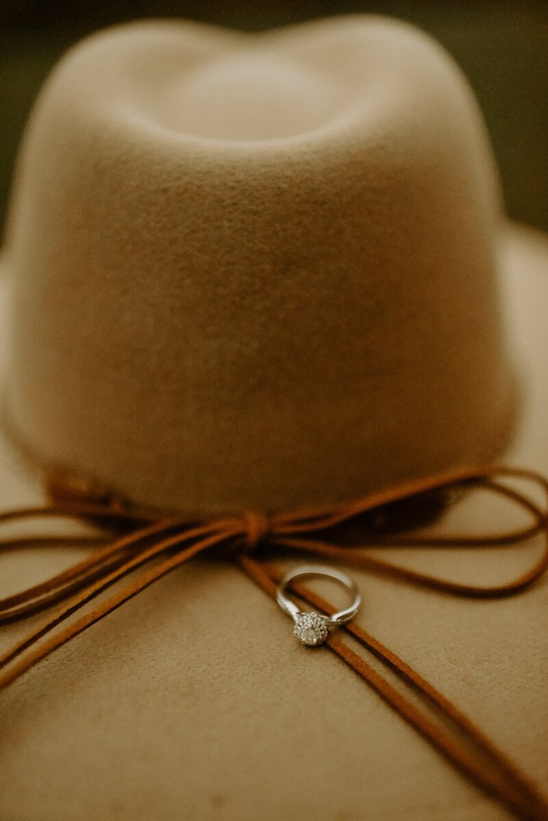 a brown hat and an engagement ring