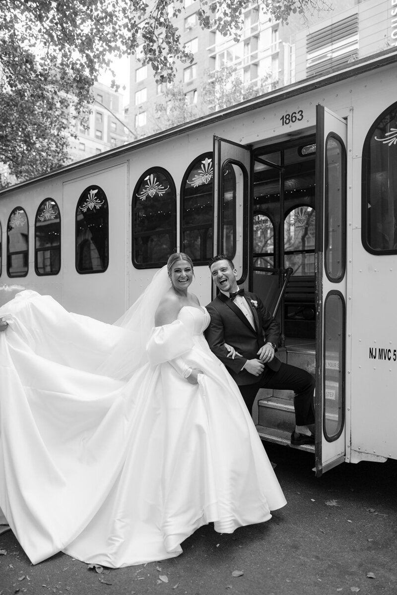 bride and groom smiling going into bus